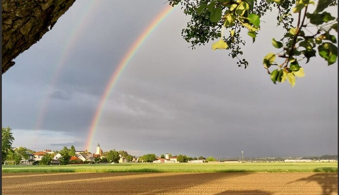 Licht überflutet das Land_ Kirche und Regenbogen